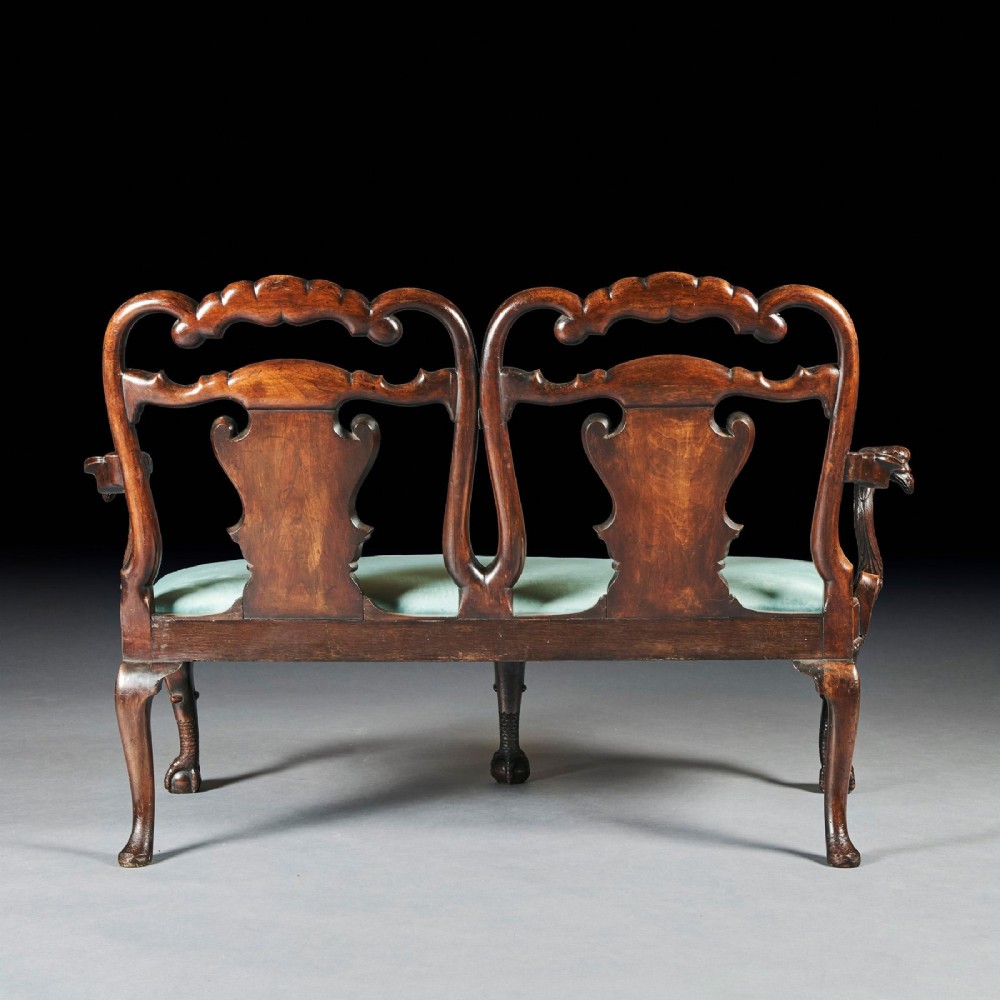 A late nineteenth-century walnut twin chair back sofa featuring vasiform splats, shell carving, cabriole legs with claw and ball feet, and a teal upholstered seat. View VII