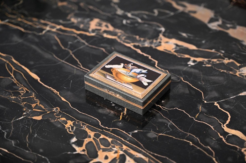 A rectangular green jasper snuff box featuring a detailed micromosaic plaque inset on the lid framed by a chase-carved gold border depicting four doves perched on a golden bowl against a dark background. View VII