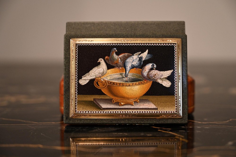 A rectangular green jasper snuff box featuring a detailed micromosaic plaque inset on the lid framed by a chase-carved gold border depicting four doves perched on a golden bowl against a dark background. View X