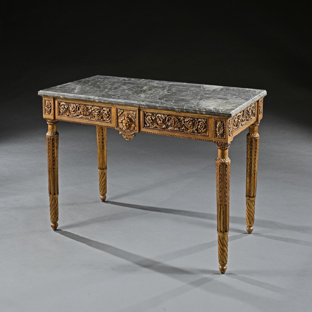 An 18th-century Italian Neoclassical console table featuring a grey veined marble top, an intricate giltwood frieze with a central carved mask, and fluted legs.