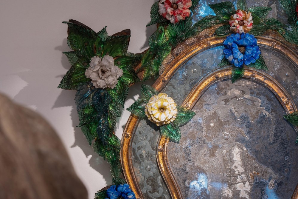A pair of 18th-century Venetian Murano glass wall mirrors featuring decorative glass foliage, colourful glass flowers, etched central mirror plates, and gilt accents. View X