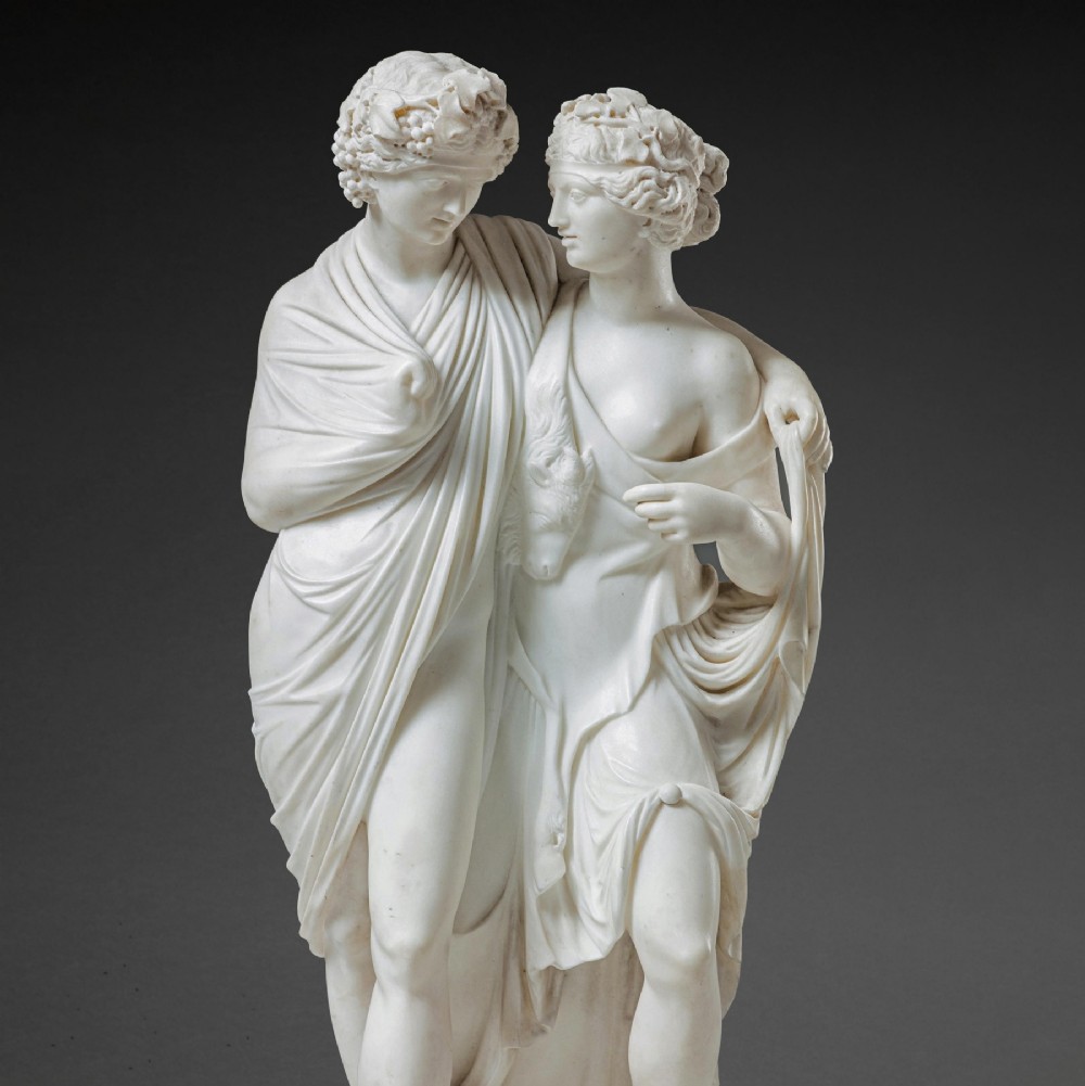 A hand-carved white marble Neoclassical sculpture depicting the classical mythological figures of Bacchus and Ariadne standing together on a circular integral base. View III