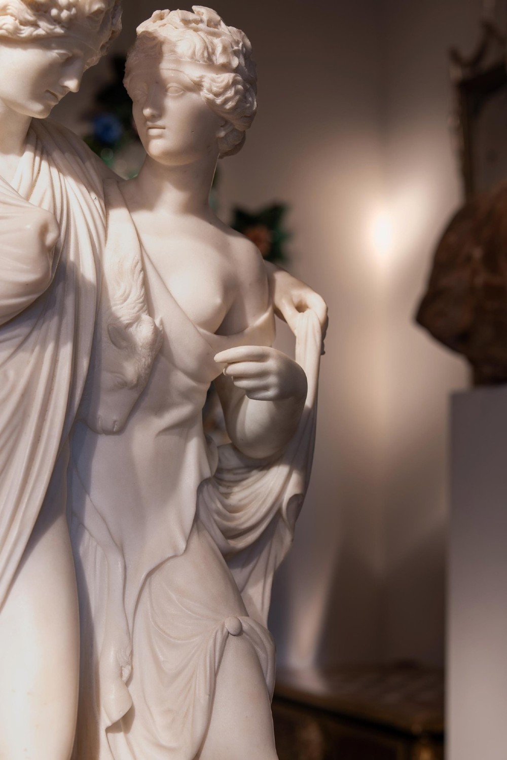 A hand-carved white marble Neoclassical sculpture depicting the classical mythological figures of Bacchus and Ariadne standing together on a circular integral base. View VII