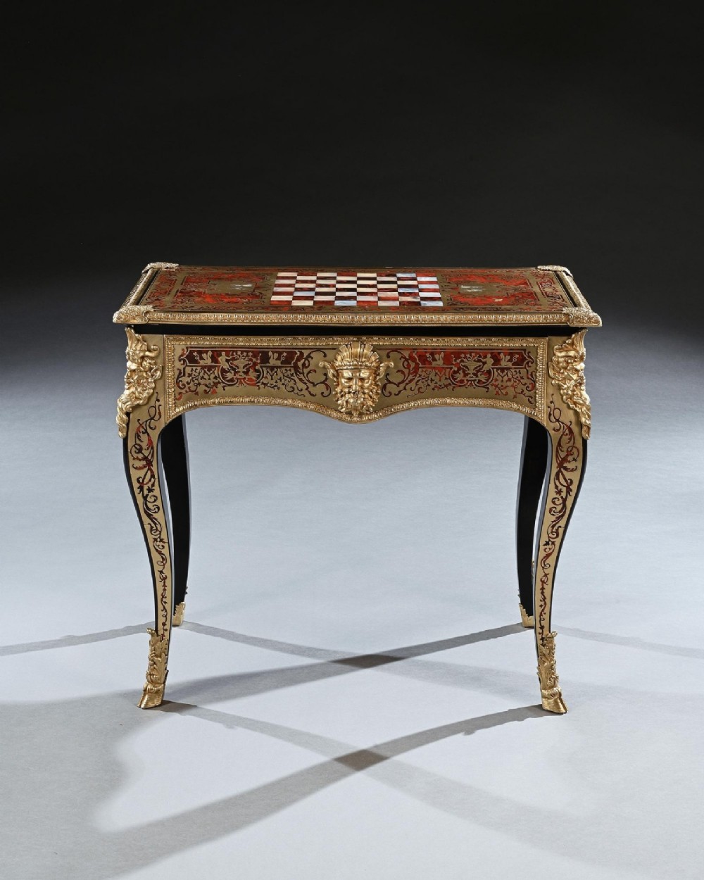 A George IV period Boulle marquetry games table featuring brass and tortoiseshell inlay, gilt-bronze mounts, cabriole legs, and an inlaid chessboard top. View II