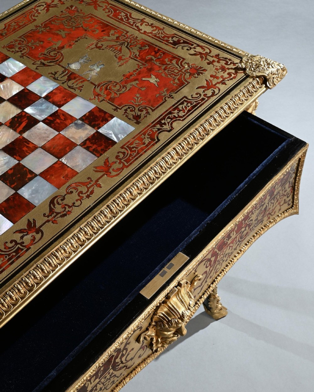 A George IV period Boulle marquetry games table featuring brass and tortoiseshell inlay, gilt-bronze mounts, cabriole legs, and an inlaid chessboard top. View X