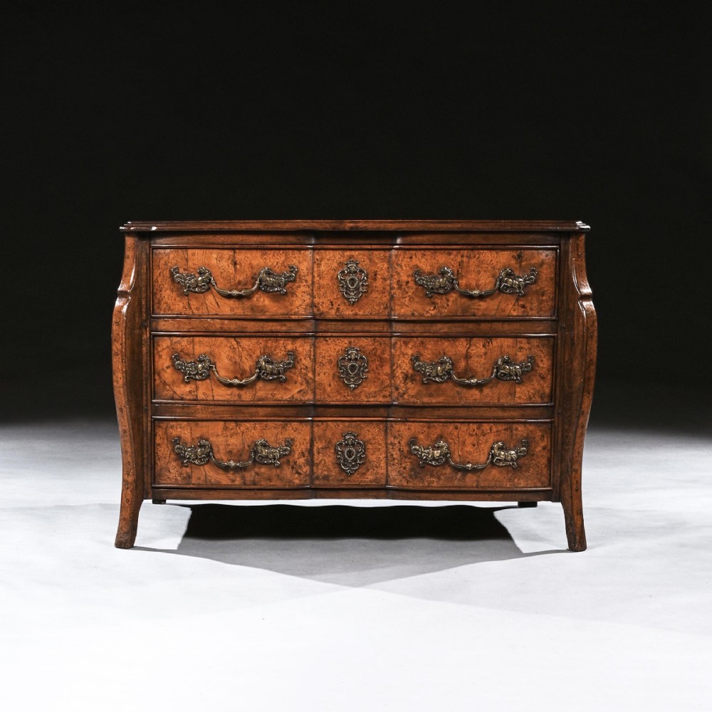 An 18th-century French Louis XV provincial commode made from figured burr elm with three drawers and cast brass handles. View II