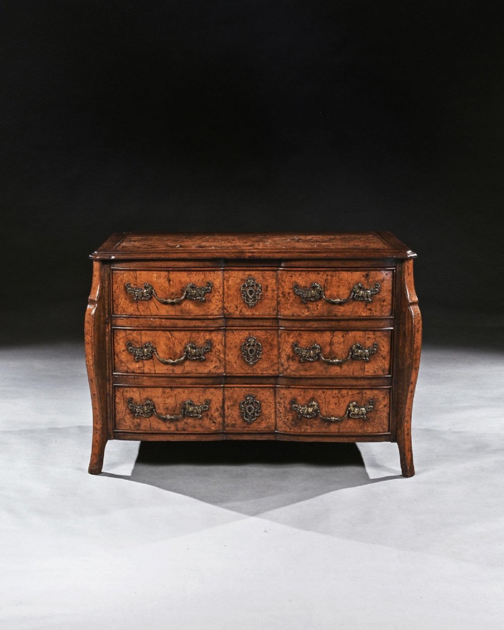 An 18th-century French Louis XV provincial commode made from figured burr elm with three drawers and cast brass handles. View III