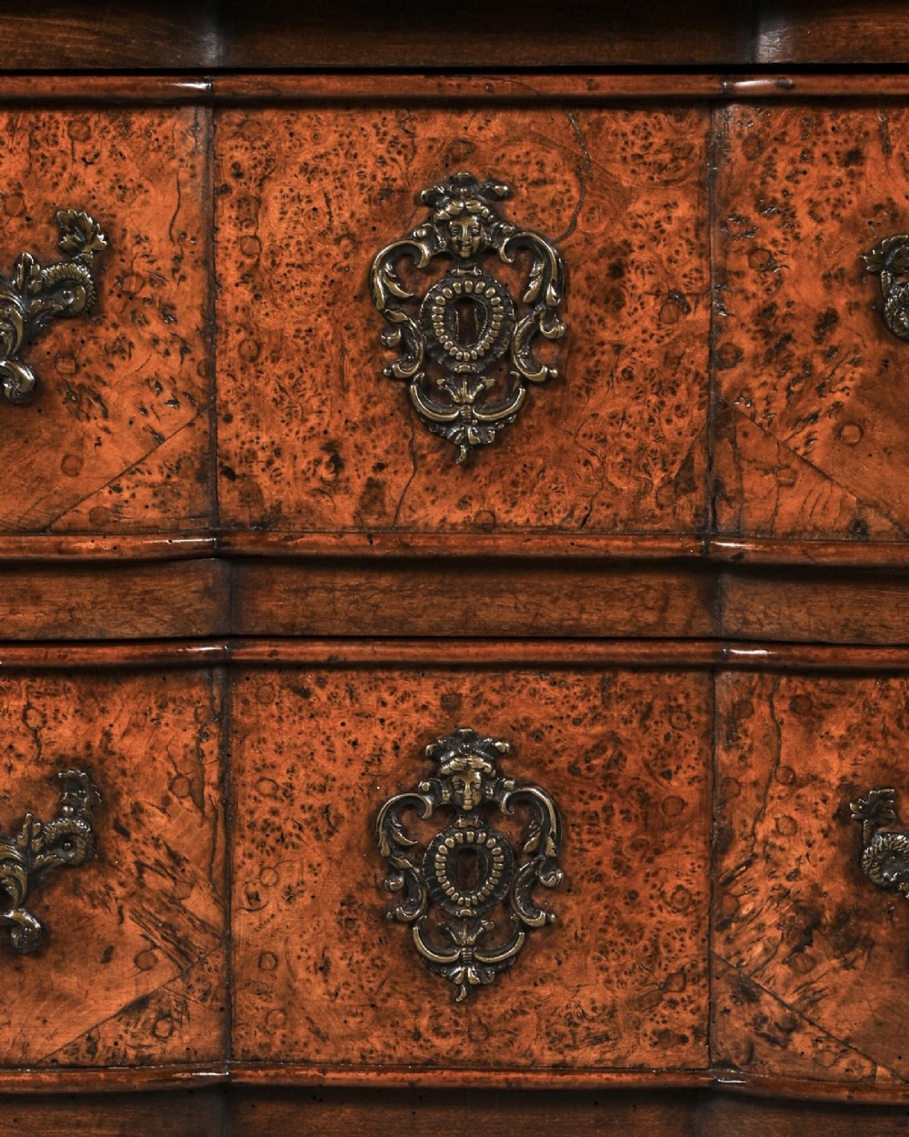 An 18th-century French Louis XV provincial commode made from figured burr elm with three drawers and cast brass handles. View IV