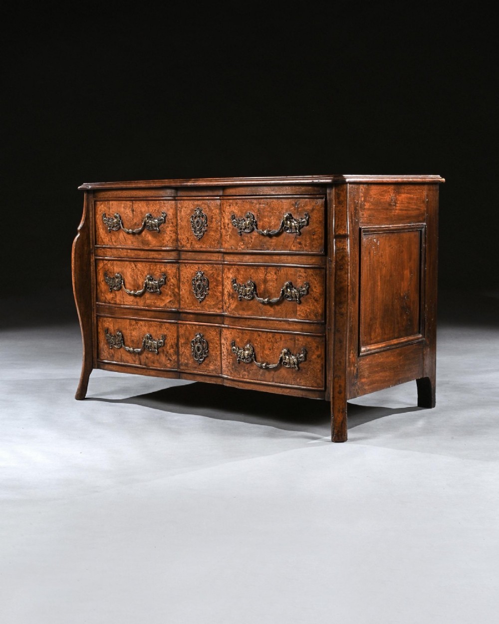 An 18th-century French Louis XV provincial commode made from figured burr elm with three drawers and cast brass handles. View VI