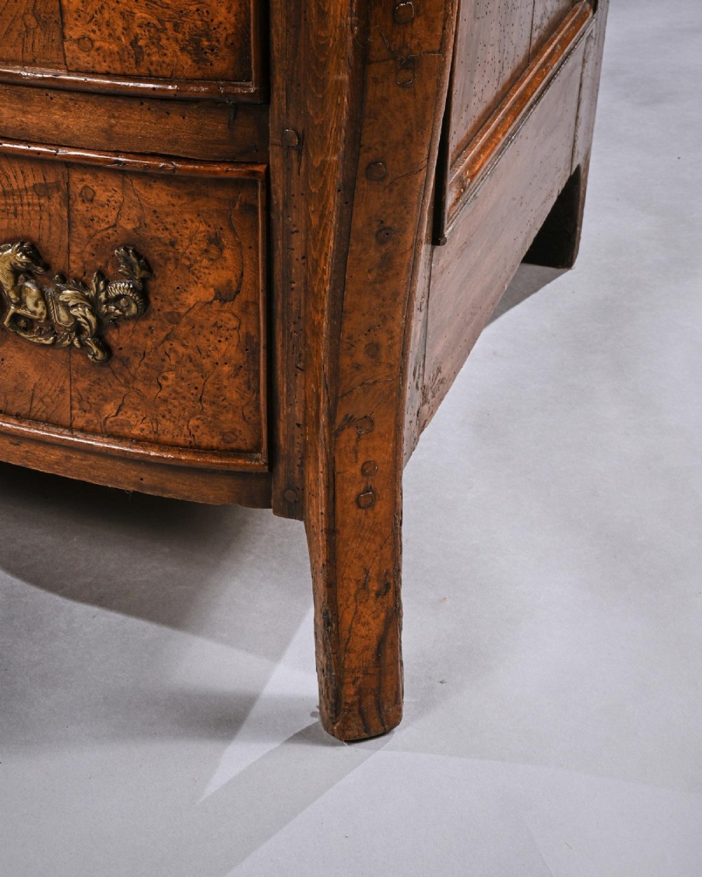 An 18th-century French Louis XV provincial commode made from figured burr elm with three drawers and cast brass handles. View IX