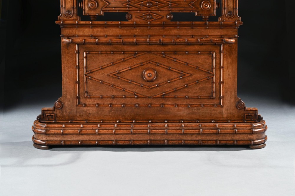A late 19th-century French Aesthetic Period hall stand made from birdseye maple featuring turned faux bamboo detailing, a central rectangular mirror, coat hooks, geometric carved panelling, and an umbrella rack base. View II