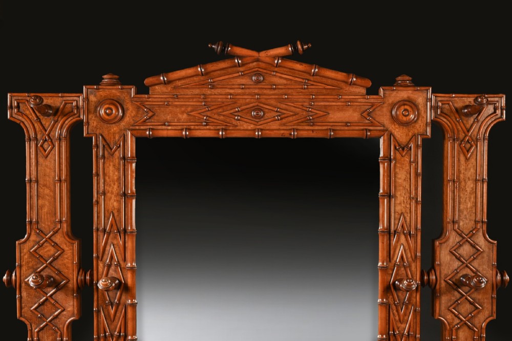 A late 19th-century French Aesthetic Period hall stand made from birdseye maple featuring turned faux bamboo detailing, a central rectangular mirror, coat hooks, geometric carved panelling, and an umbrella rack base. View VI