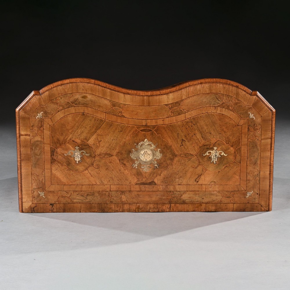 A mid-eighteenth-century German serpentine walnut commode featuring three drawers decorated with metal marquetry inlays, brass handles, and carved corner feet. View VII