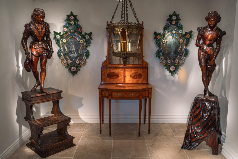 A pair of carved brown wood figures depicting Renaissance figures atop detailed wooden bases. View III