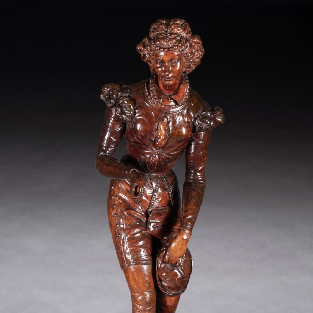 A pair of carved brown wood figures depicting Renaissance figures atop detailed wooden bases. View VI