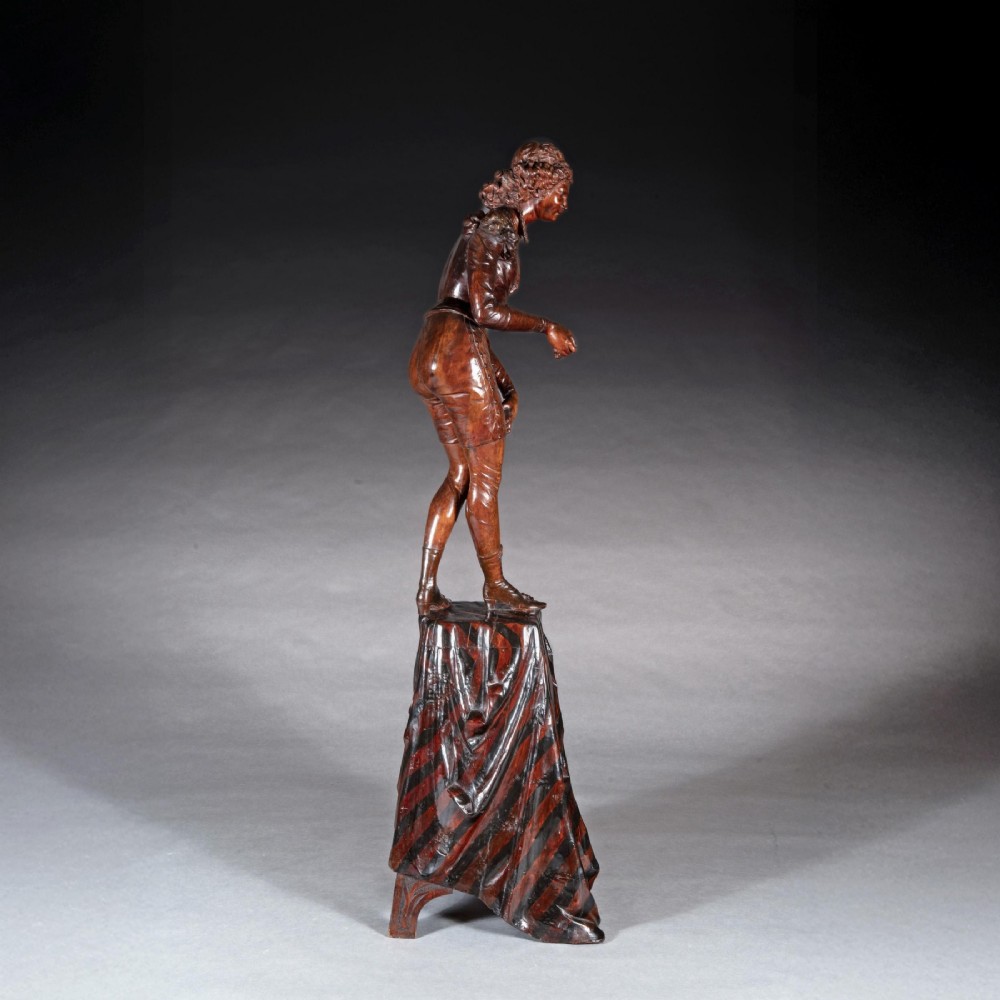 A pair of carved brown wood figures depicting Renaissance figures atop detailed wooden bases. View VIII