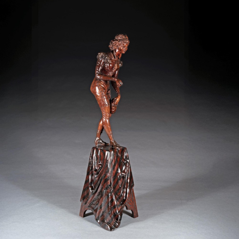 A pair of carved brown wood figures depicting Renaissance figures atop detailed wooden bases. View IX