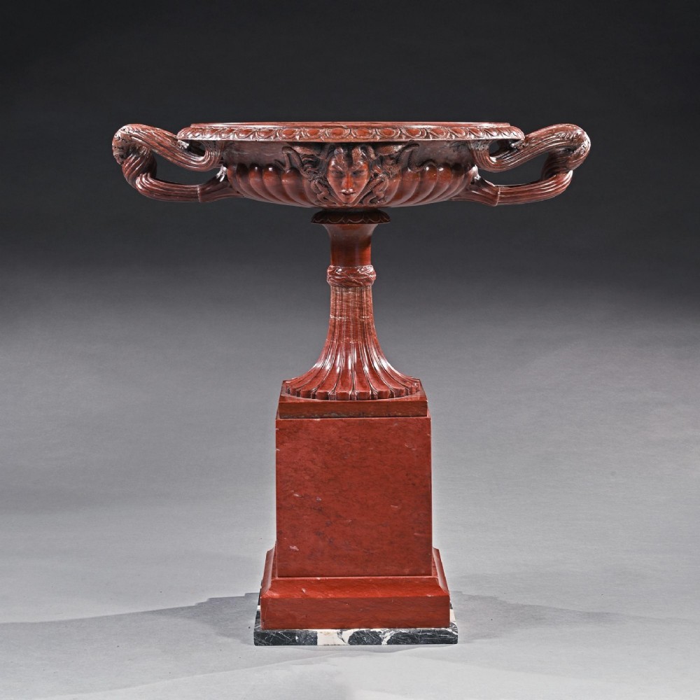 A carved deep red Rosso Antico marble tazza featuring serpent handles, a Medusa mask motif, and a fluted stem set upon a square pedestal base. View II