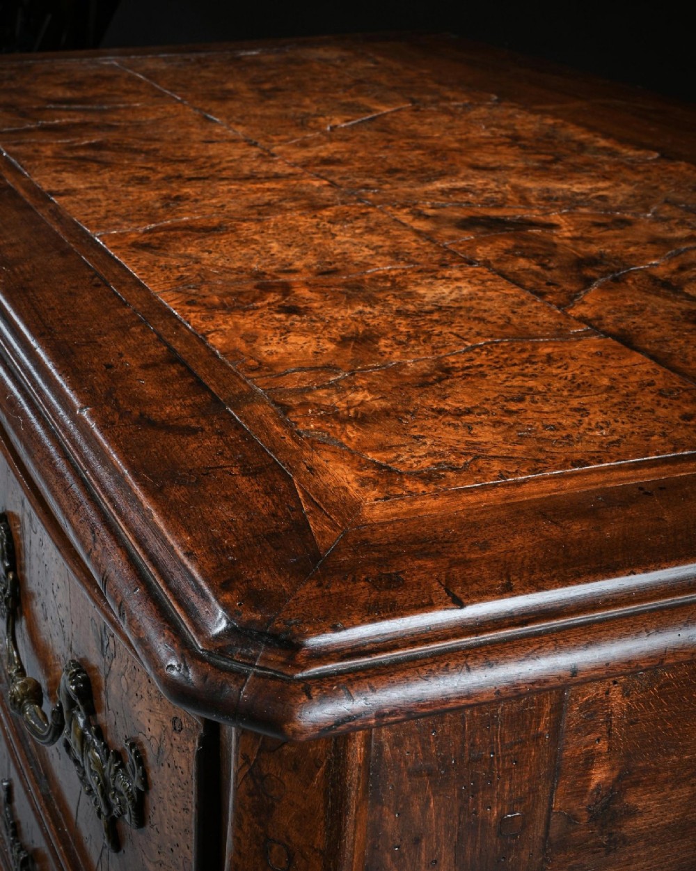 An eighteenth-century French provincial burr elm commode featuring three shaped drawers with ornate brass handles and escutcheons. View VIII
