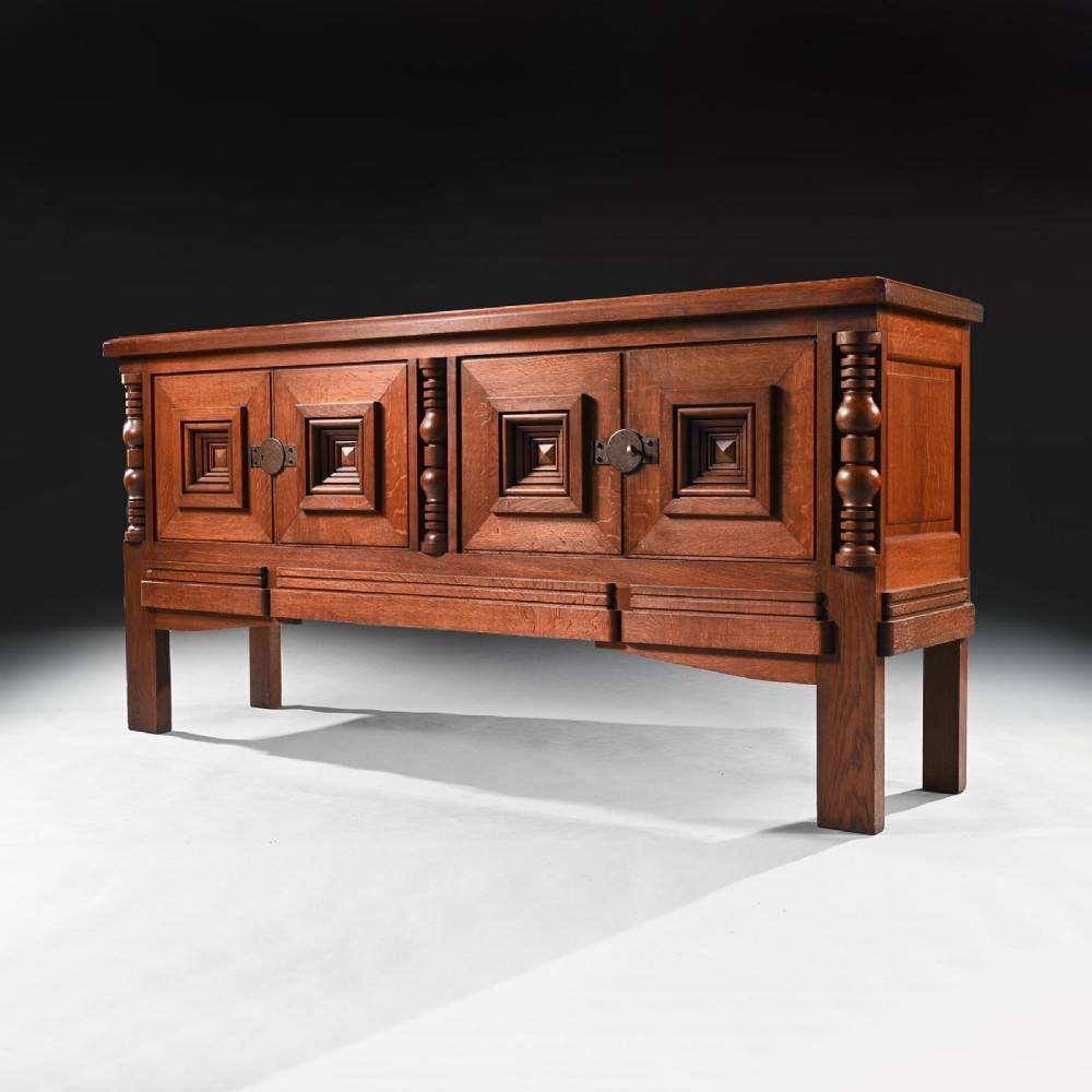 Mid-twentieth-century French oak sideboard featuring four cabinet doors with raised geometric diamond panels and turned wooden column accents. View II
