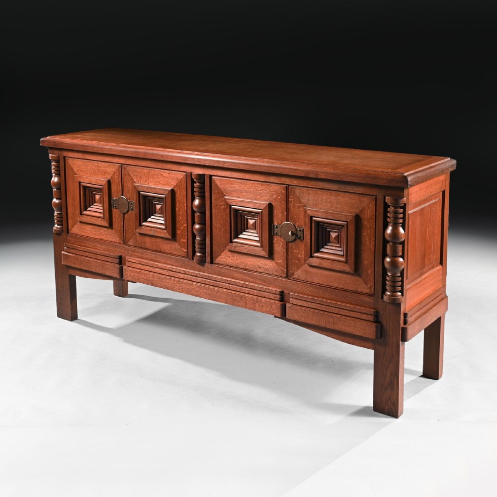 Mid-twentieth-century French oak sideboard featuring four cabinet doors with raised geometric diamond panels and turned wooden column accents. View IV