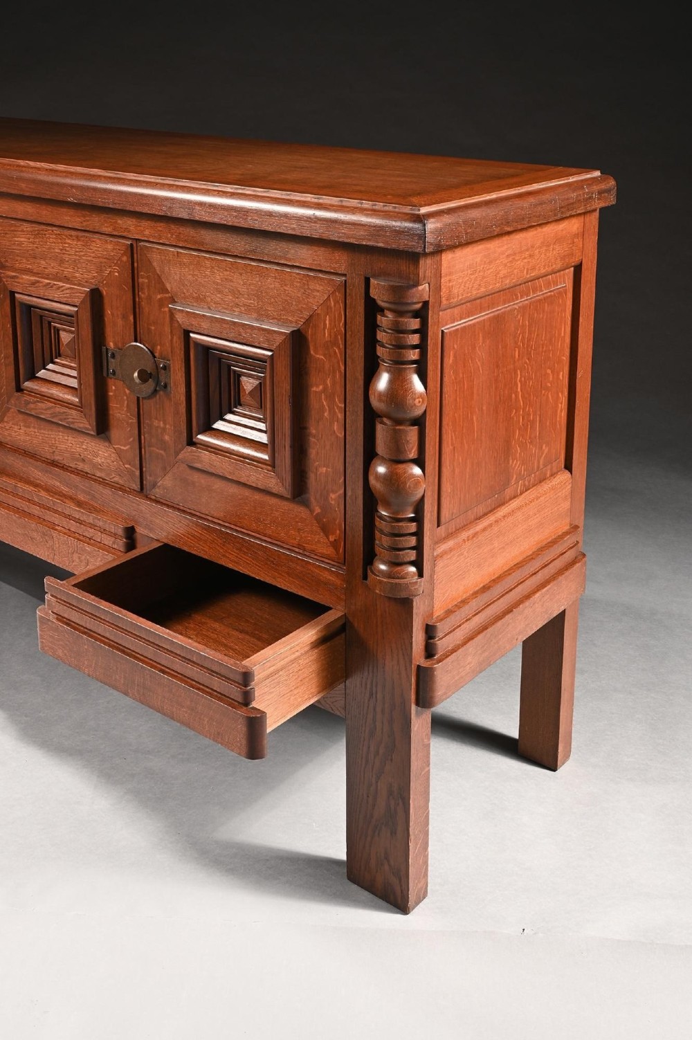 Mid-twentieth-century French oak sideboard featuring four cabinet doors with raised geometric diamond panels and turned wooden column accents. View V