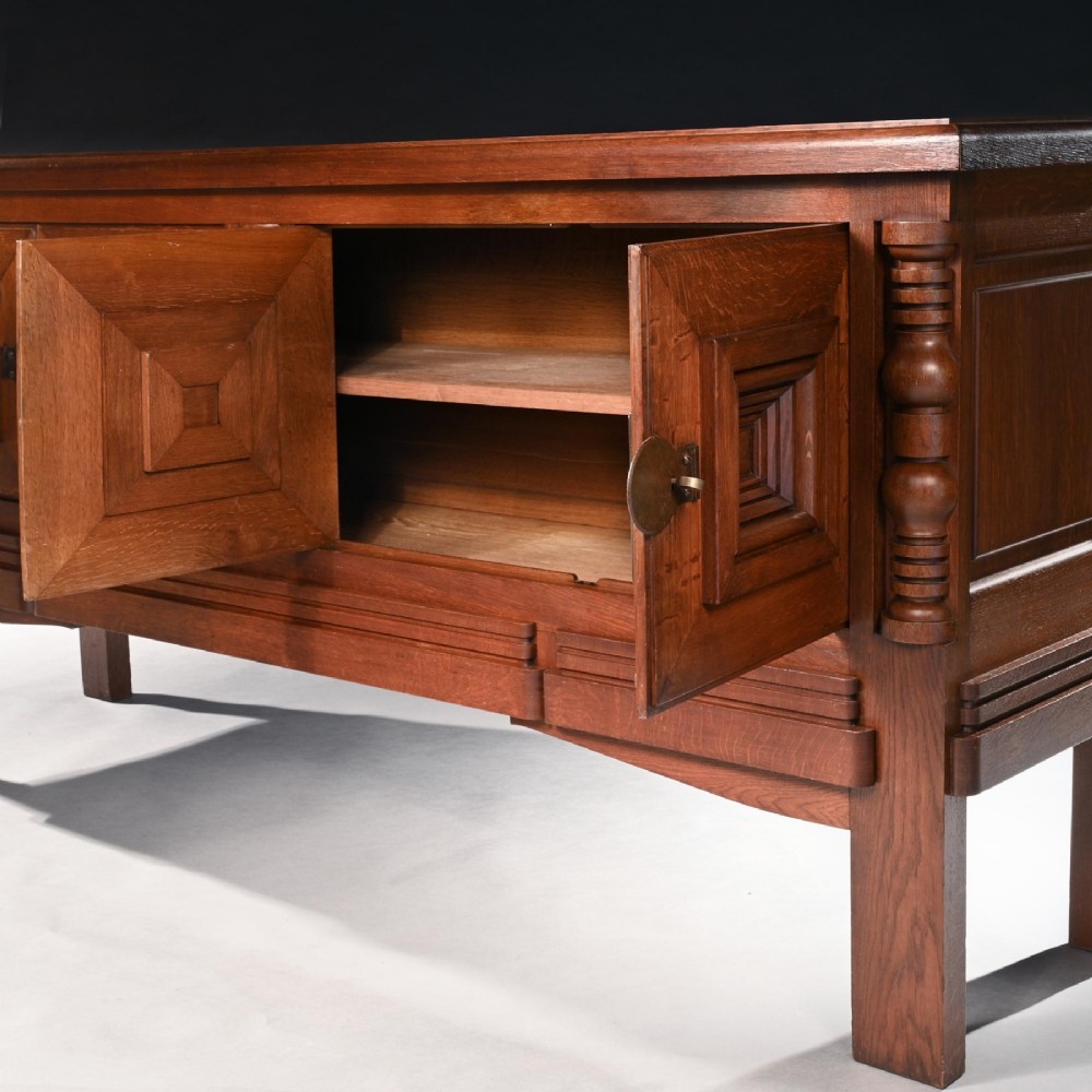 Mid-twentieth-century French oak sideboard featuring four cabinet doors with raised geometric diamond panels and turned wooden column accents. View VII