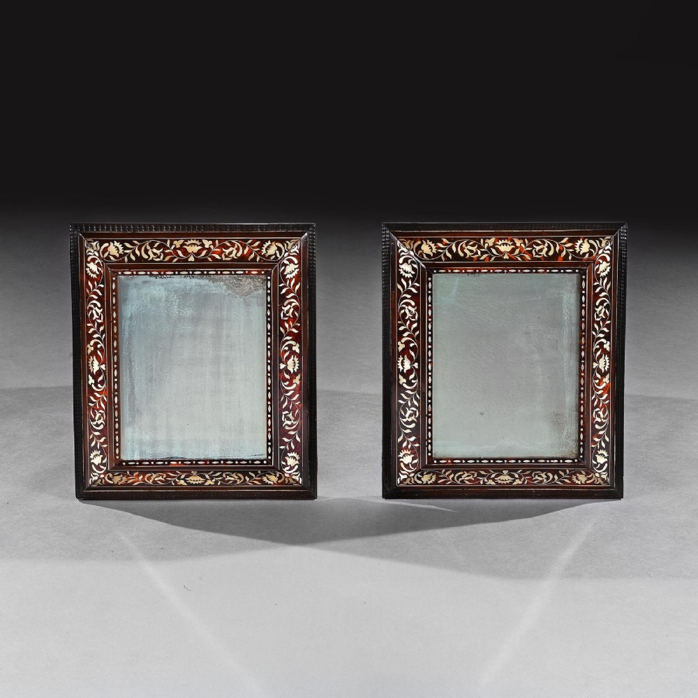 A pair of 18th-century rectangular wall mirrors featuring rich brown tortoiseshell frames intricately inlaid with mother-of-pearl floral motifs.