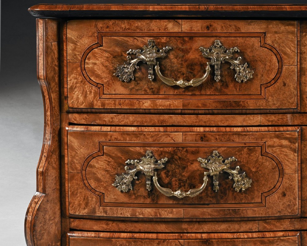An 18th-century French Regence commode crafted from burr maple veneer featuring three drawers with detailed gilt-bronze handles, keyhole escutcheons, and foot mounts. View VII