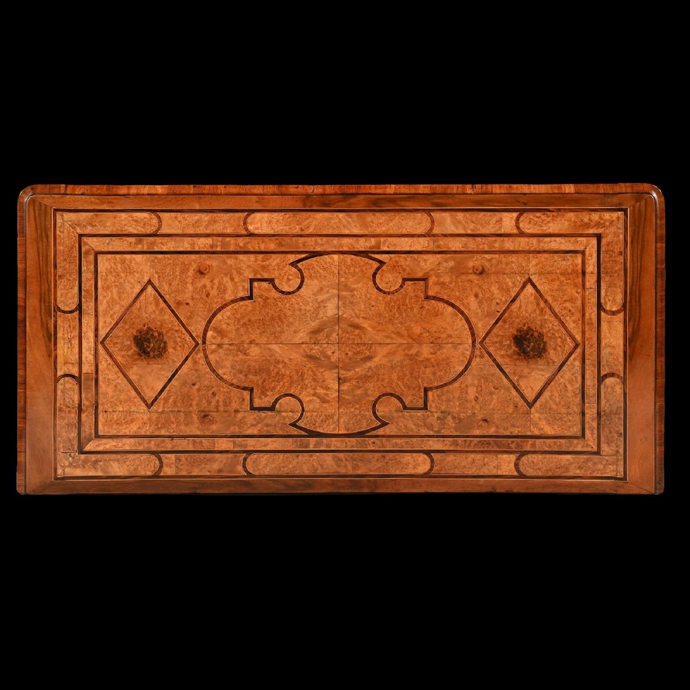 An 18th-century French Regence commode crafted from burr maple veneer featuring three drawers with detailed gilt-bronze handles, keyhole escutcheons, and foot mounts. View X