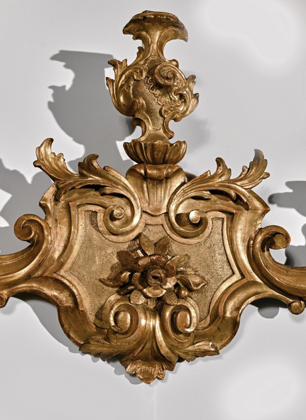 A pair of carved giltwood wall sconces featuring ornate rococo scrollwork, acanthus leaf motifs, and twin candle arms against a dark backdrop. View VII