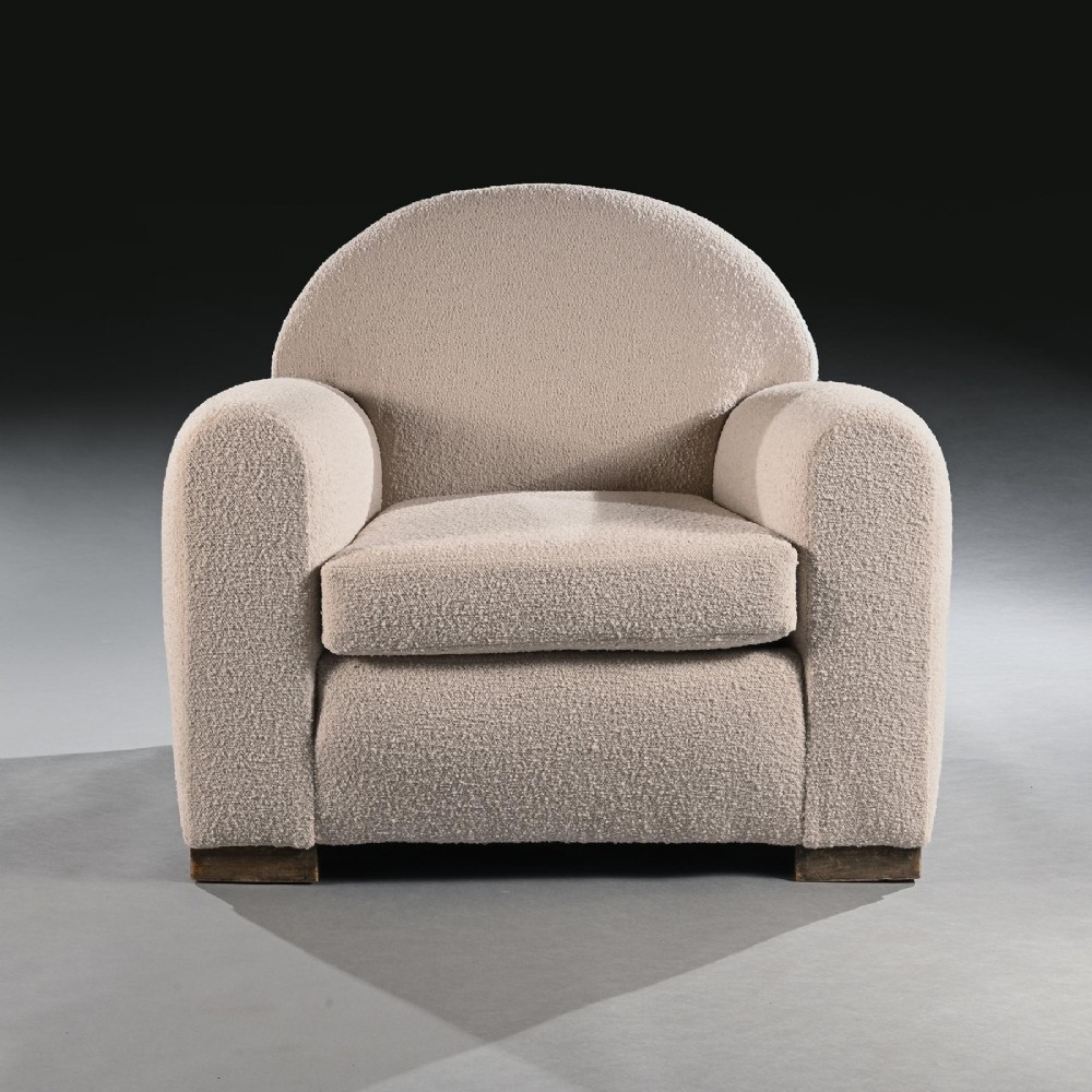 A pair of mid-20th-century French club armchairs upholstered in textured cream boucle fabric with rounded arched backrests and wooden block feet. View VI
