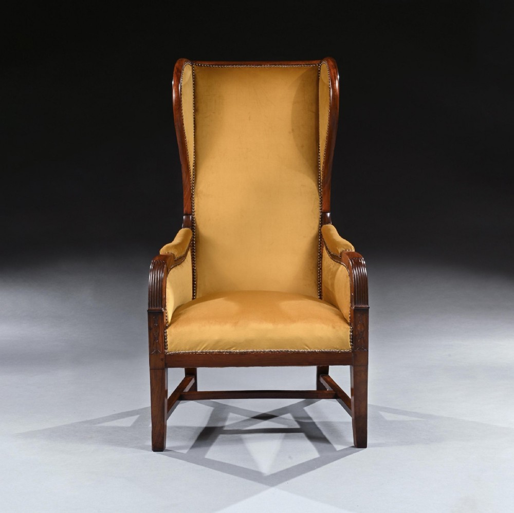 A French Empire mahogany wingback armchair upholstered in gold velvet with studded brass trim and a side reclining mechanism. View II