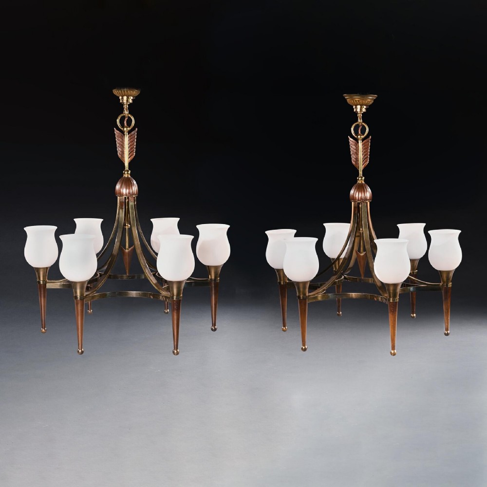 A pair of mid-century brass chandeliers featuring six arms each, topped with tulip-shaped frosted glass shades and decorative arrow stem motifs.