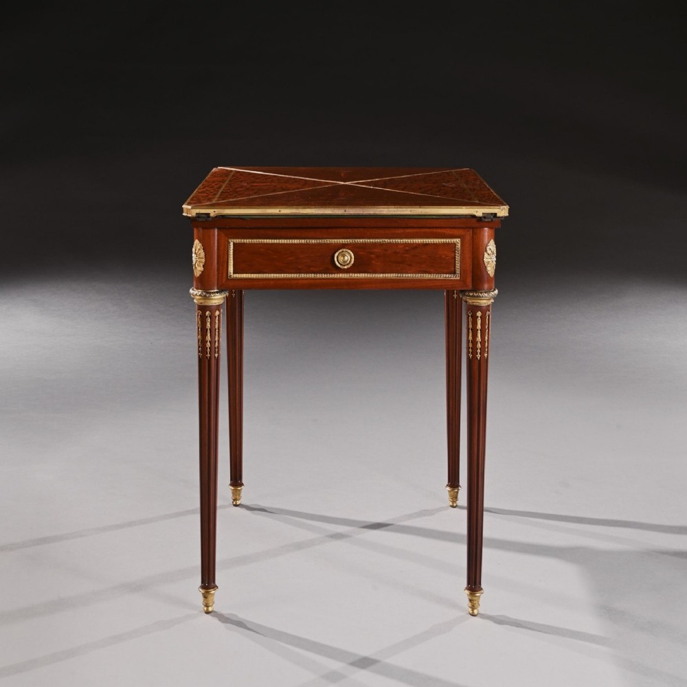 A late 19th-century mahogany envelope card table featuring fluted tapered legs, gilt-bronze mounts, and a single frieze drawer. View II