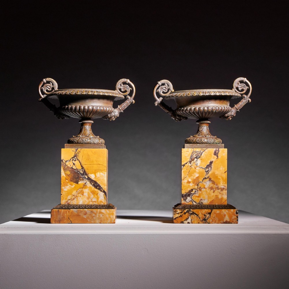 A pair of early nineteenth-century French bronze tazzas with scrolled handles resting on square yellow veined marble pedestal bases. View III