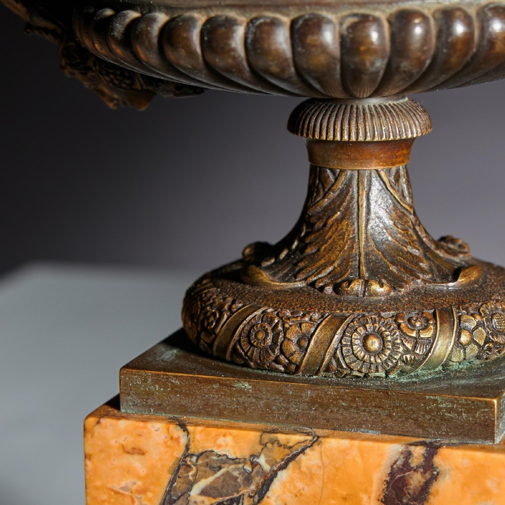 A pair of early nineteenth-century French bronze tazzas with scrolled handles resting on square yellow veined marble pedestal bases. View VI