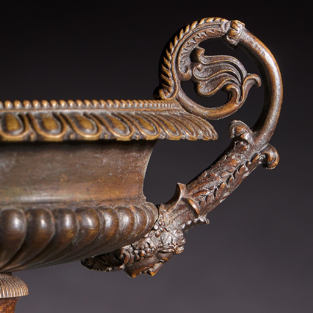 A pair of early nineteenth-century French bronze tazzas with scrolled handles resting on square yellow veined marble pedestal bases. View IX