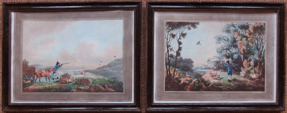 A pair of framed Georgian sporting prints depicting figures with guns and working dogs in open landscapes, housed within dark wood frames.