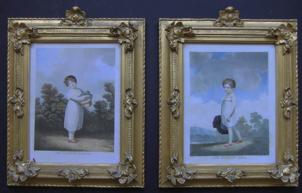 A pair of gilt-framed 1807 stipple engravings depicting young children in white garments set against landscape backgrounds.