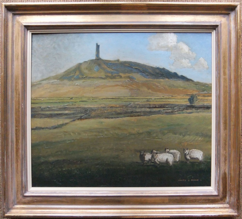 A framed oil painting depicting Castle Hill in Huddersfield with sheep grazing in a green pastoral field beneath a pale sky.