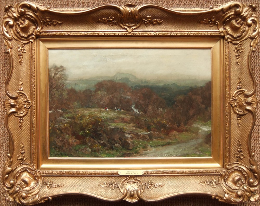 An atmospheric landscape oil painting depicting misty hills under a grey sky, set within an ornate swept gold giltwood frame.