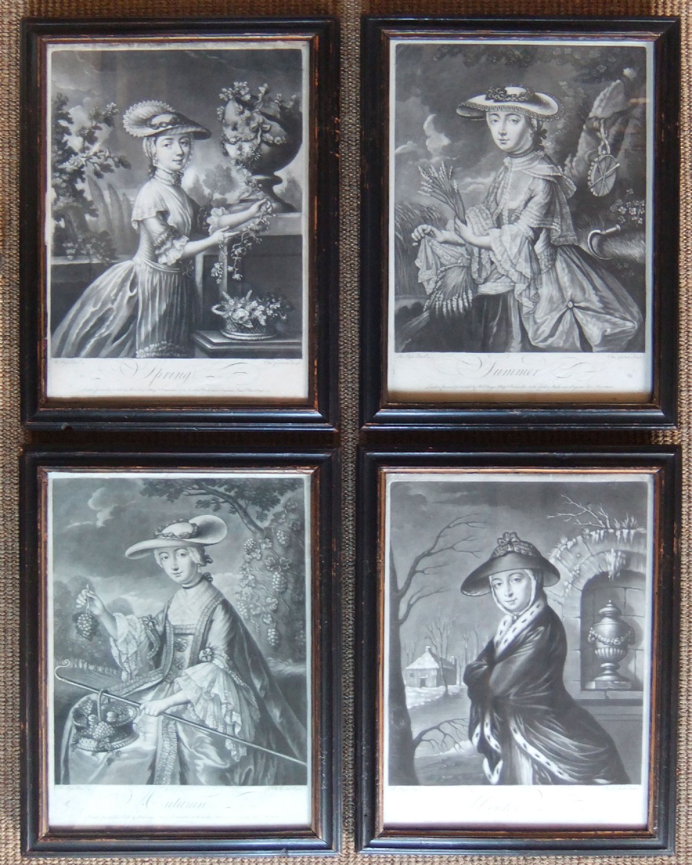 A set of four framed 18th-century monochrome mezzotint prints depicting allegorical female representations of the four seasons in dark wooden frames.