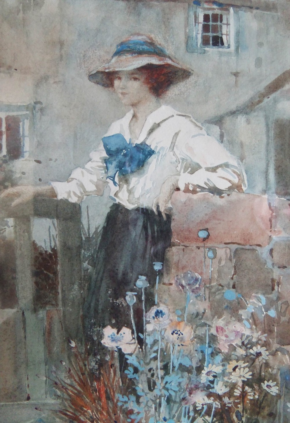 A watercolour portrait painting depicting a woman wearing a wide-brimmed hat leaning against a stone wall beside a wooden cottage gate and blooming flowers. View III