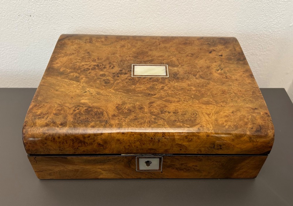 A rectangular Victorian burr walnut box featuring rounded edges, a mother-of-pearl central cartouche inlay, and a matching keyhole escutcheon. View II