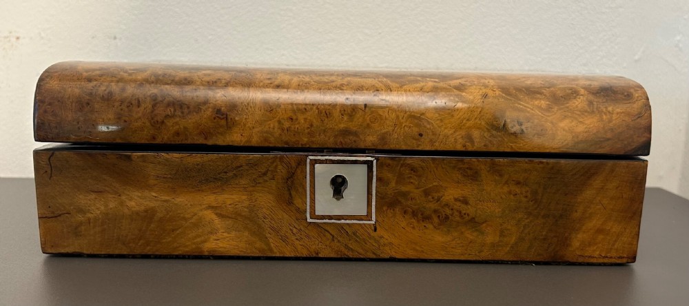 A rectangular Victorian burr walnut box featuring rounded edges, a mother-of-pearl central cartouche inlay, and a matching keyhole escutcheon. View III