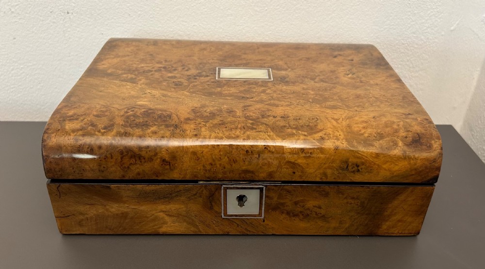 A rectangular Victorian burr walnut box featuring rounded edges, a mother-of-pearl central cartouche inlay, and a matching keyhole escutcheon. View IV