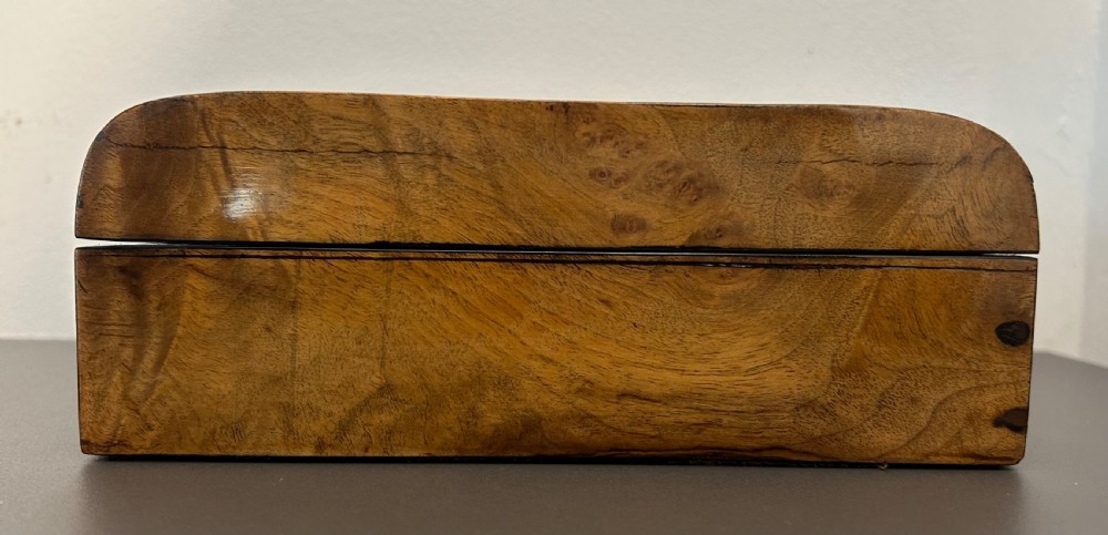A rectangular Victorian burr walnut box featuring rounded edges, a mother-of-pearl central cartouche inlay, and a matching keyhole escutcheon. View V