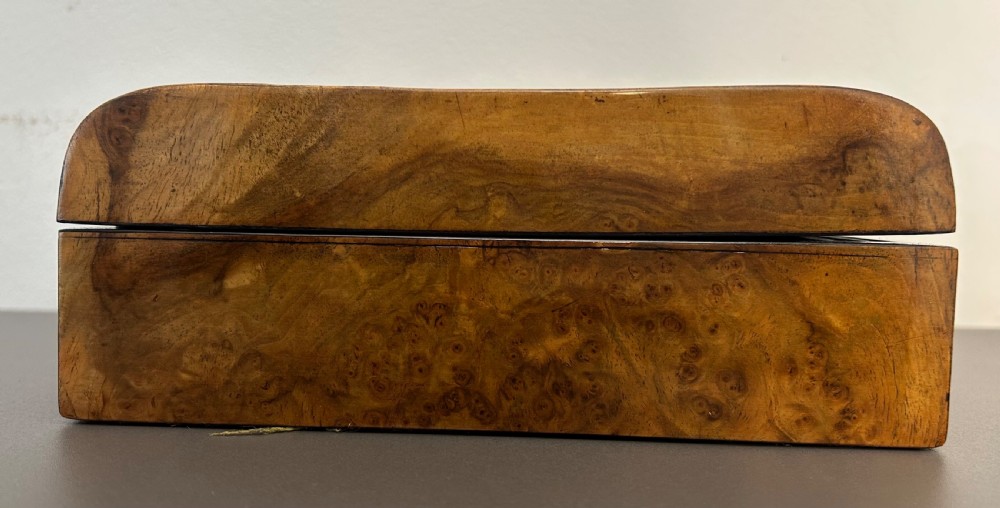 A rectangular Victorian burr walnut box featuring rounded edges, a mother-of-pearl central cartouche inlay, and a matching keyhole escutcheon. View VII