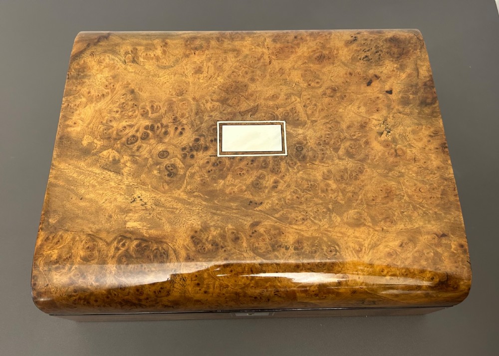 A rectangular Victorian burr walnut box featuring rounded edges, a mother-of-pearl central cartouche inlay, and a matching keyhole escutcheon. View IX